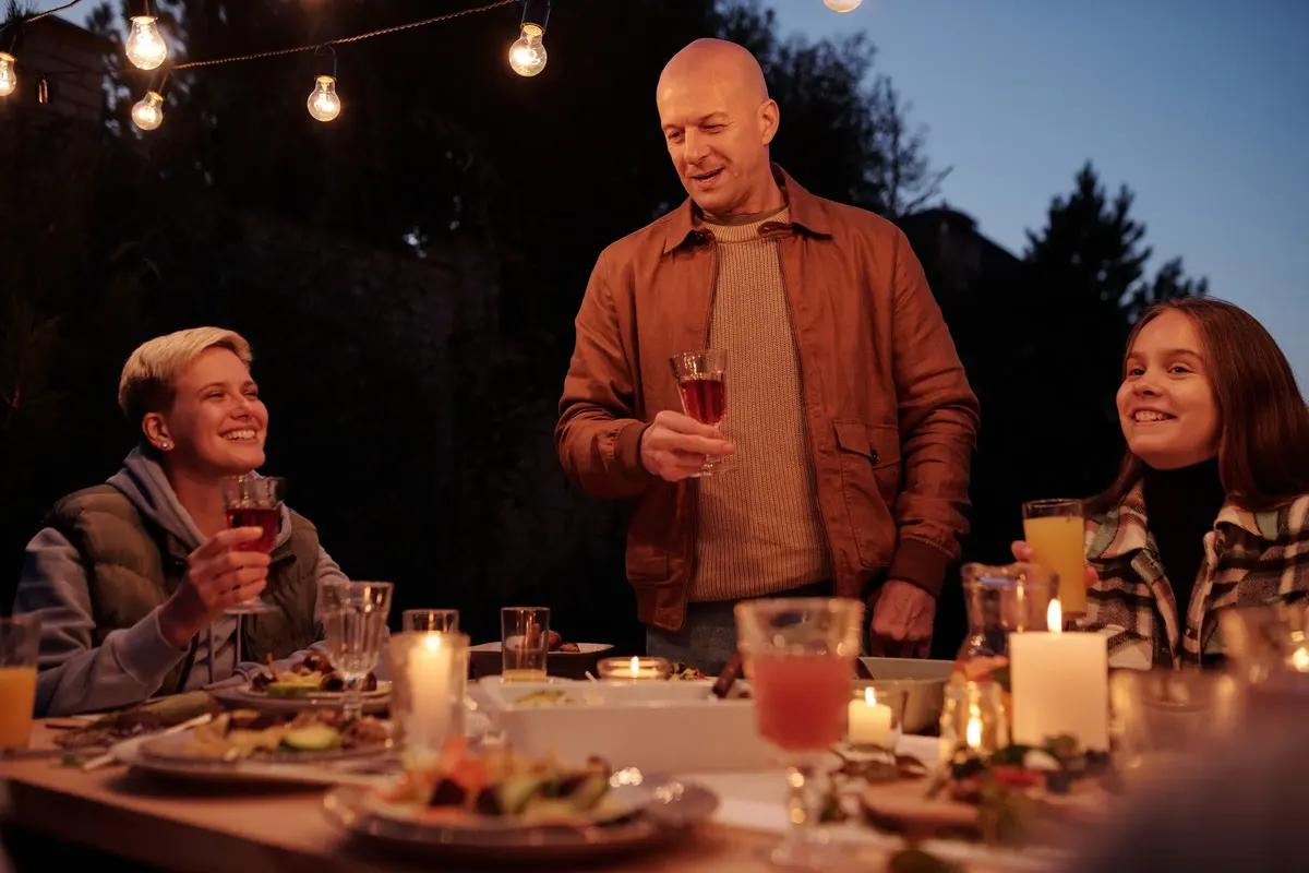 A family raising a toast at an outdoor dinner