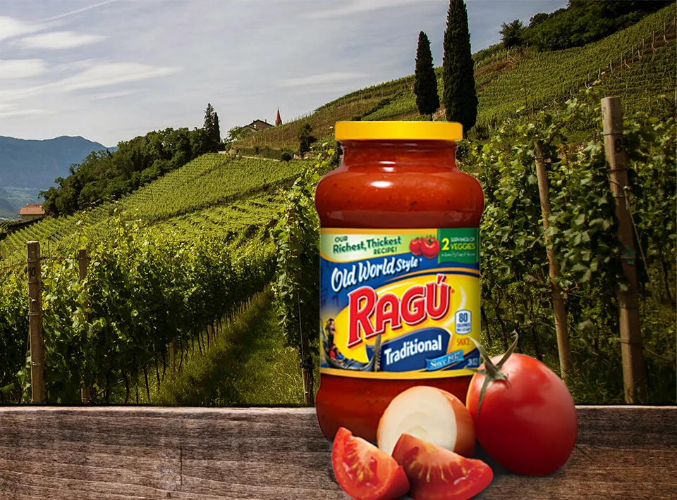 A jar of Ragú sauce in front of a vineyard