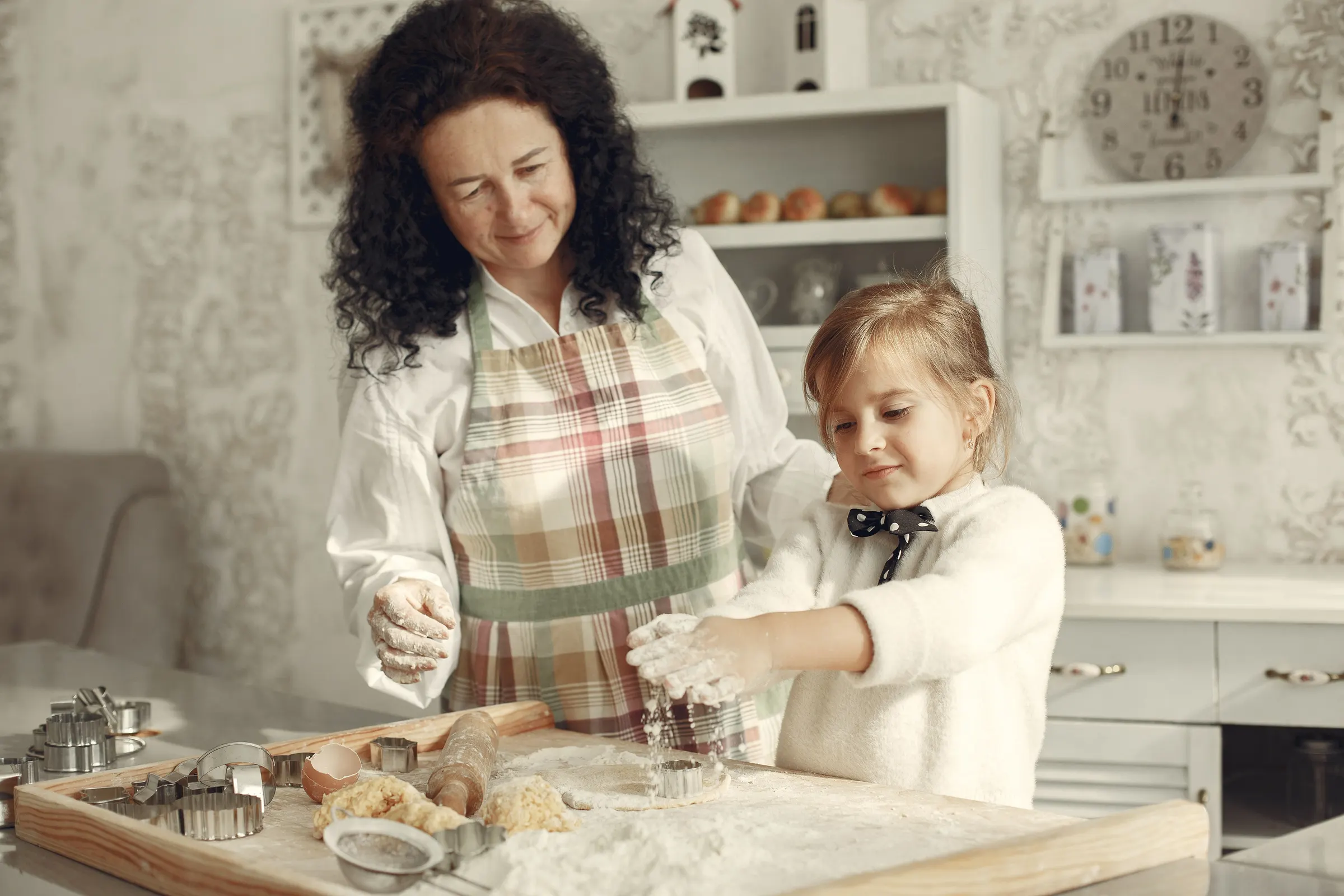 A grandmother and her granddaughter baking together in a kitchen