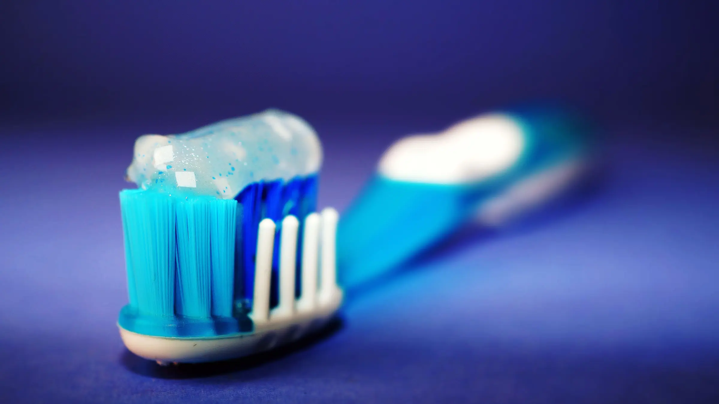 A toothbrush with blue toothpaste, close up