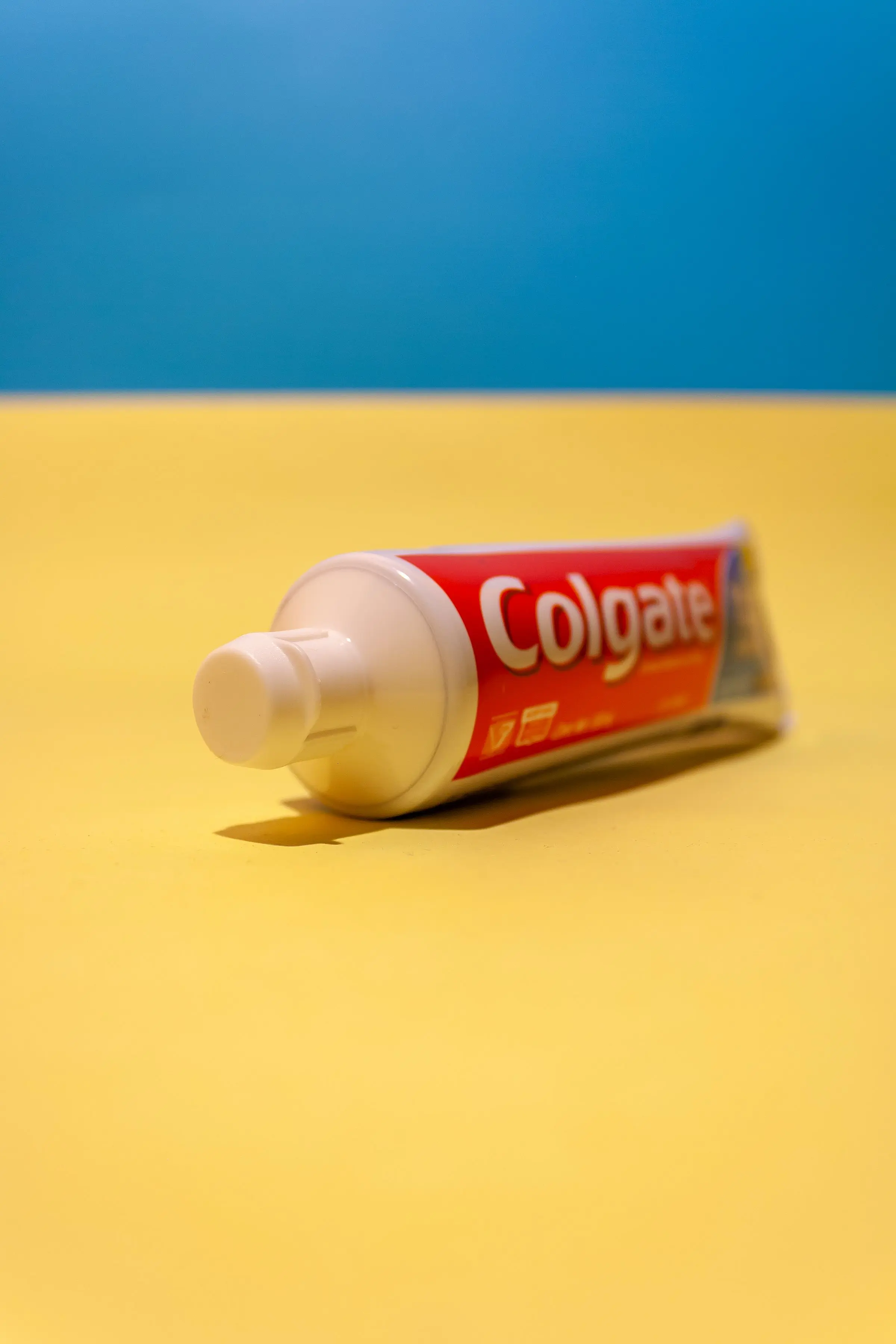 A tube of Colgate on a yellow table