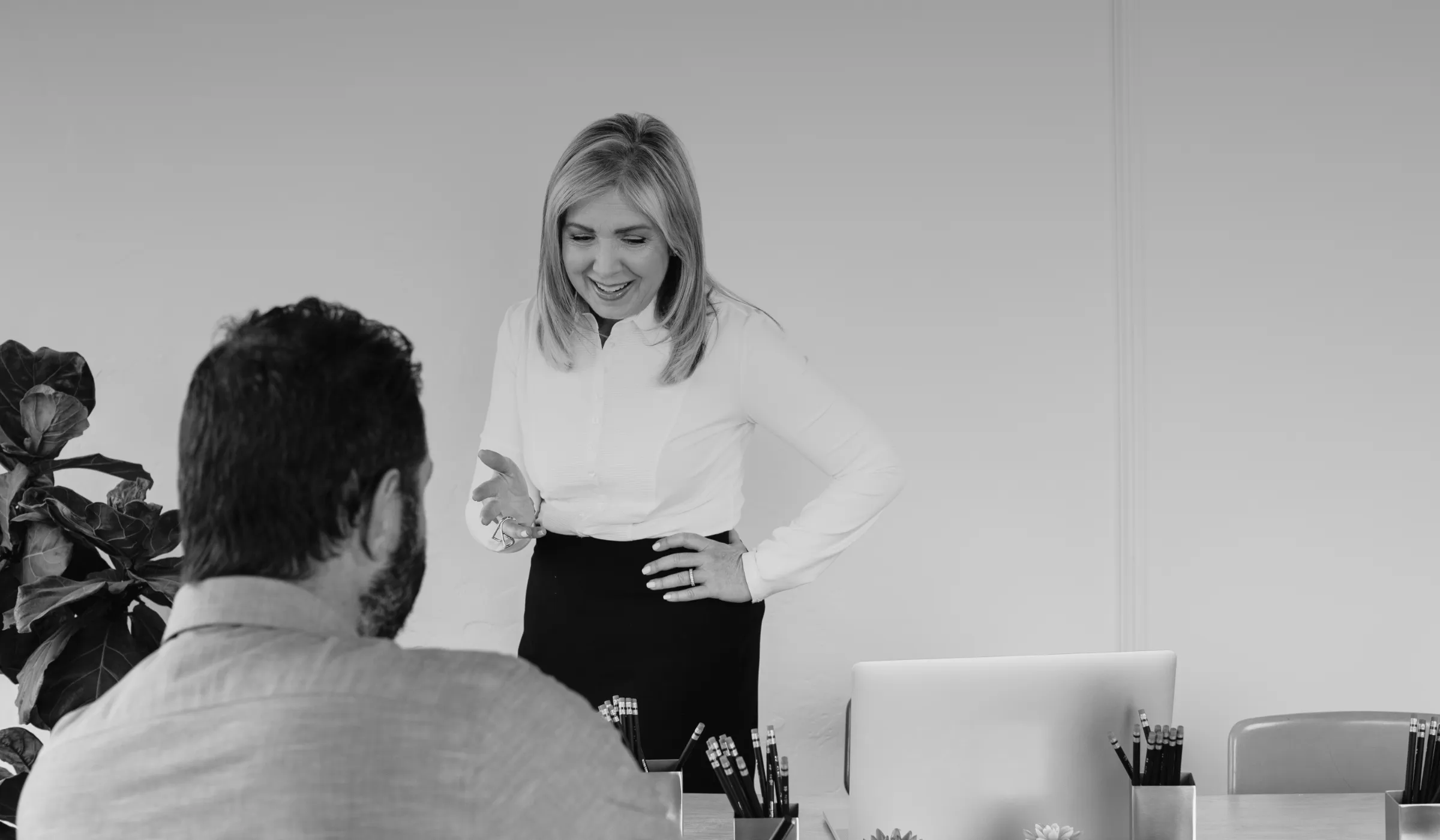 Leslie Zane talking with a colleague at a work table